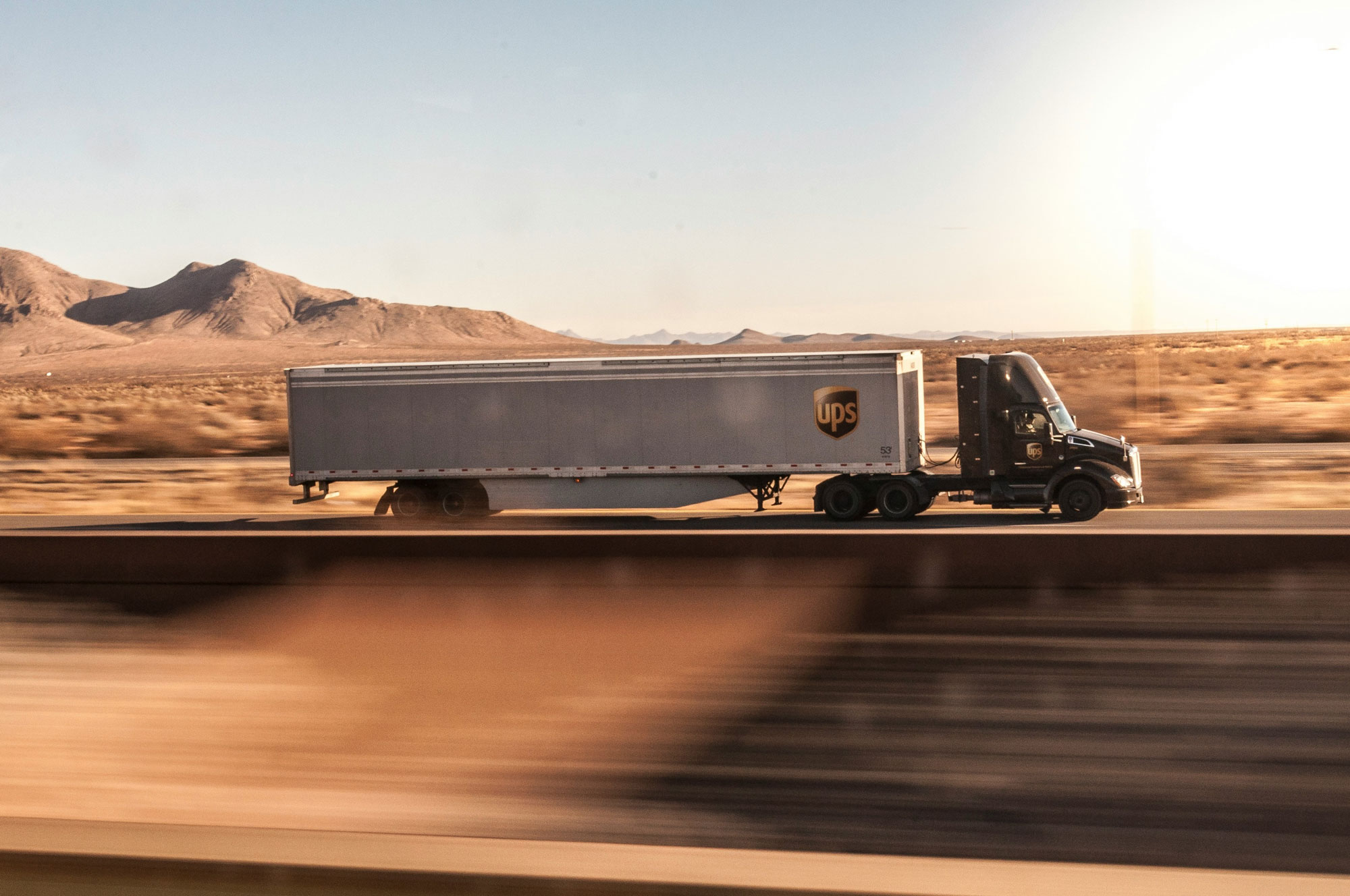 a truck driving down the road in the desert